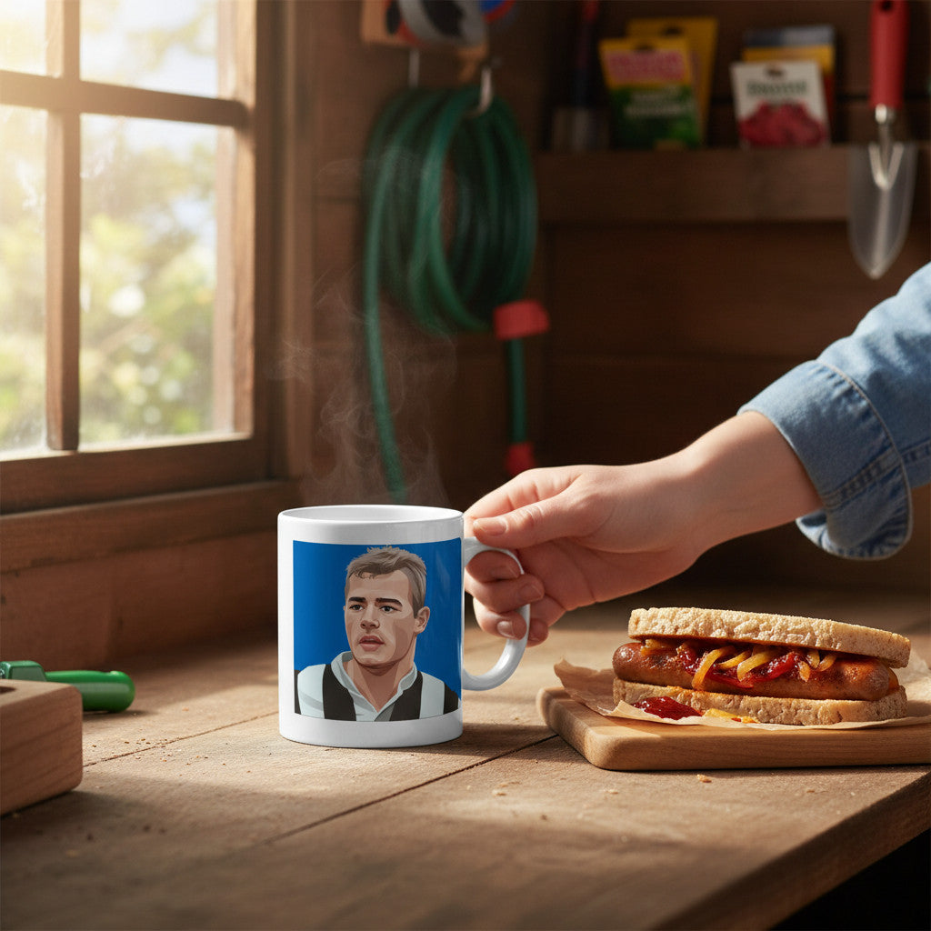 Retrotext Newcastle United ceramic mug featuring an Alan Shearer portrait, held on a wooden table next to a hot dog.