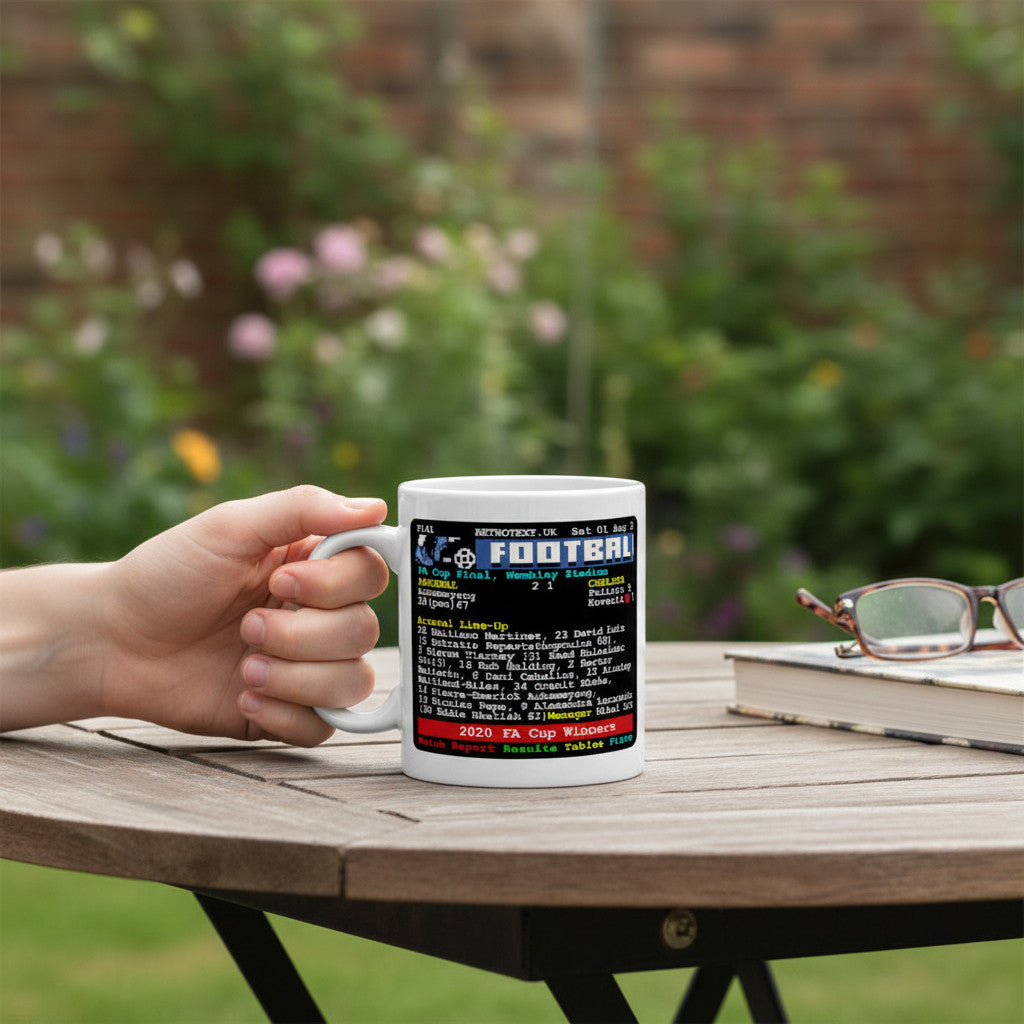 Retrotext Arsenal 2020 FA Cup Final ceramic coffee mug with teletext-style match details held in a hand outdoors.