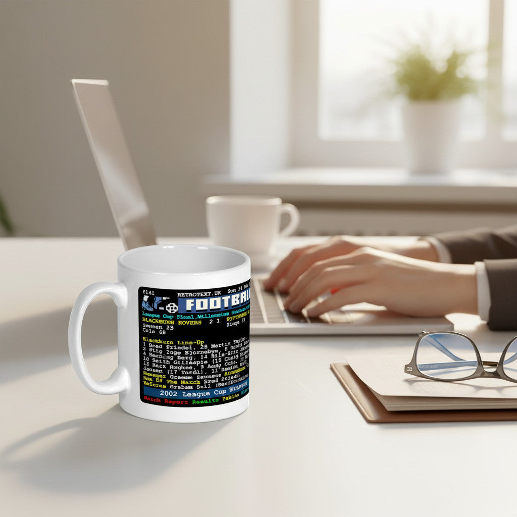 Retrotext white ceramic mug featuring a 2002 Blackburn Rovers League Cup final teletext design on a desk.