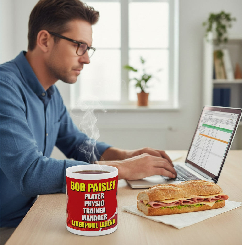 Retrotext Liverpool Bob Paisley 11oz glossy white ceramic mug featuring red text on a desk next to a sandwich