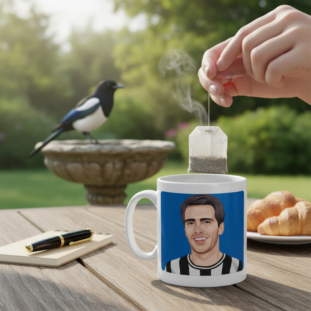 Retrotext 11oz glossy white mug featuring Newcastle United legend Bobby Moncur on a garden table with a tea bag