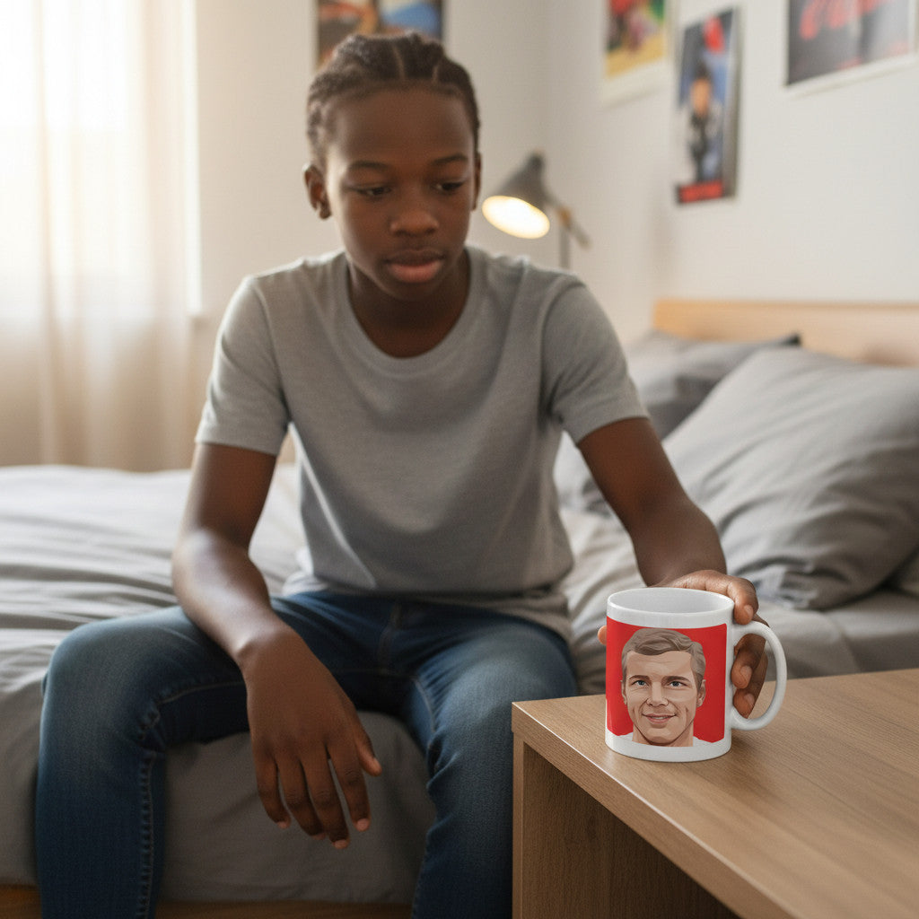Retrotext white ceramic mug featuring a Bobby Moore 1966 England World Cup graphic, held by a young man in a bedroom.