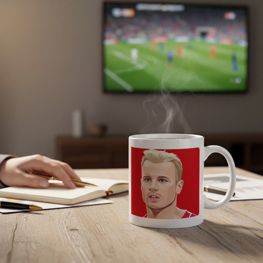Retrotext white ceramic mug featuring a Dennis Bergkamp graphic on a red background, sitting on a wooden desk.