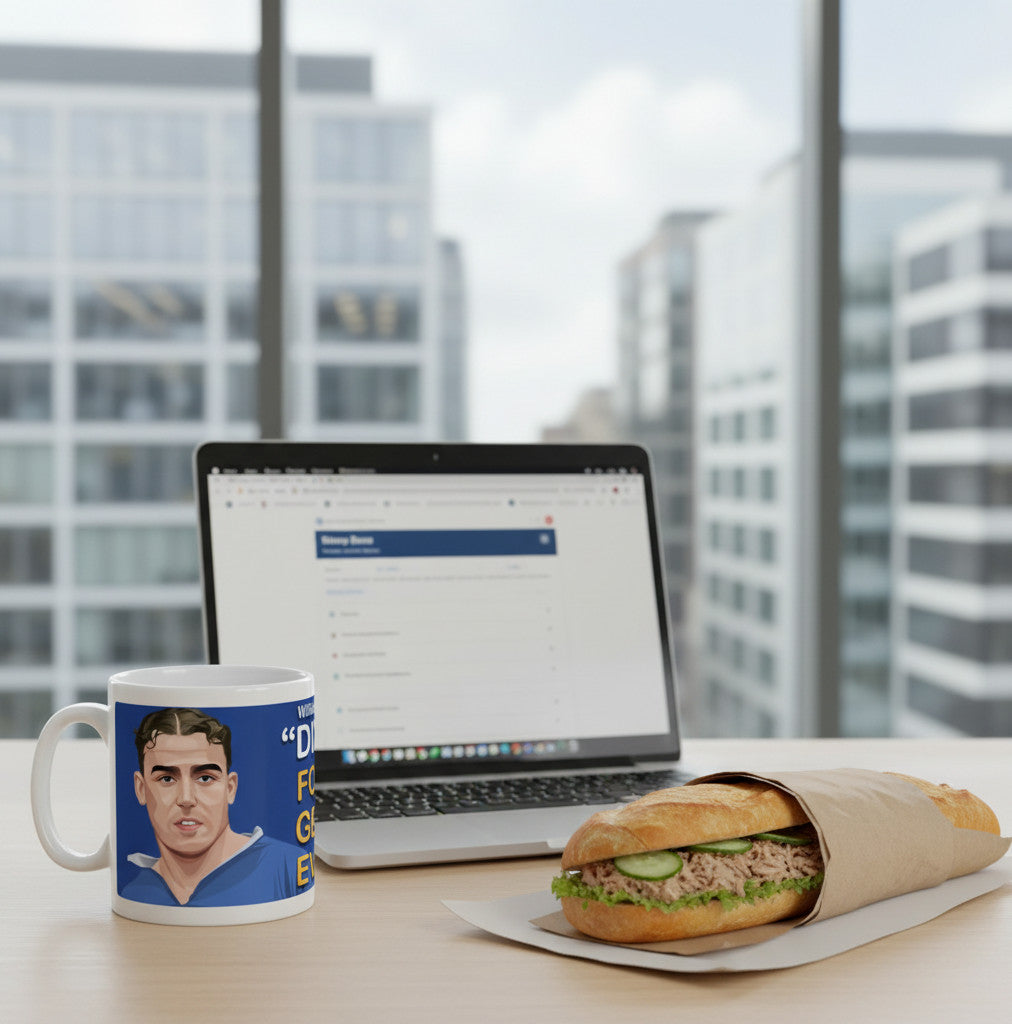 Retrotext glossy white 11oz mug featuring a portrait of Everton legend Dixie Dean on a desk with a laptop and sandwich
