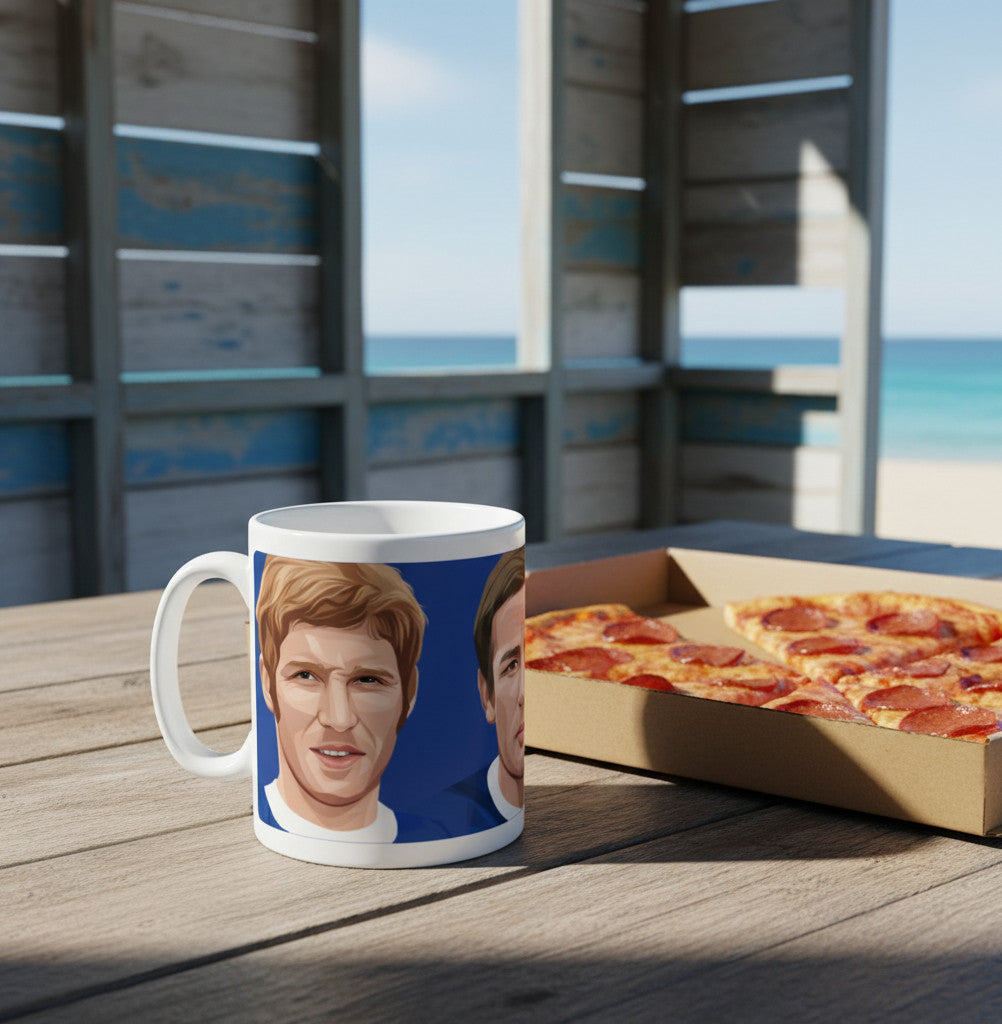 Retrotext Everton Ball Harvey Kendall ceramic mug with a blue wraparound illustration on a wooden table by the beach.