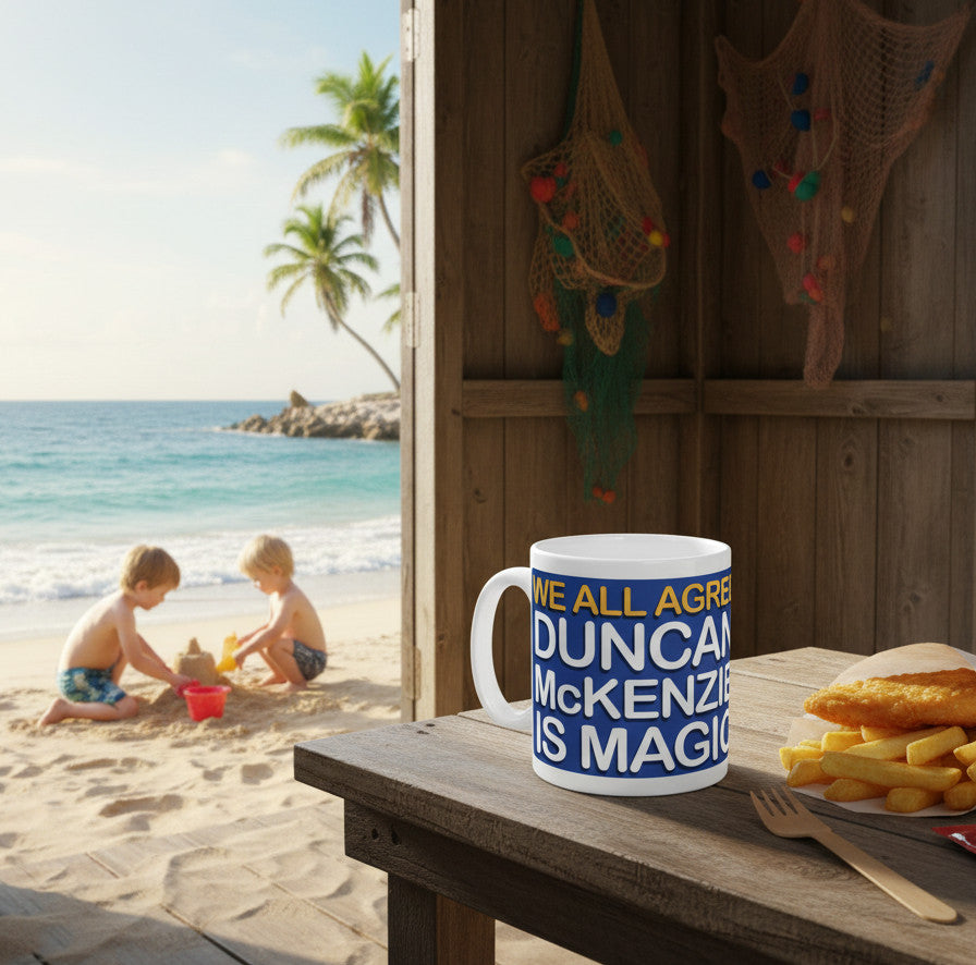 Retrotext Everton Duncan McKenzie Is Magic white ceramic mug on a wooden table with fish and chips by the beach.