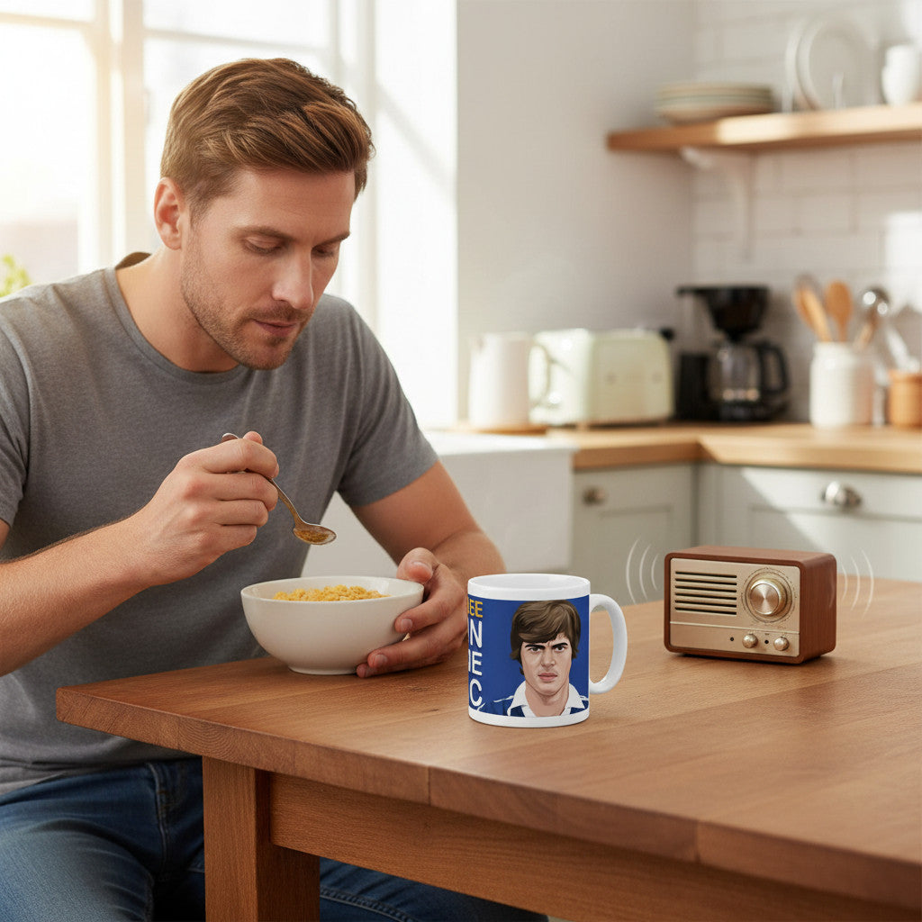 Retrotext Everton Duncan McKenzie wraparound mug on a wooden table next to a man eating breakfast in a kitchen