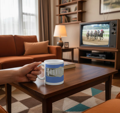 Retrotext Grandstand mug with Des Lynam design held in a hand in a cozy living room with a vintage television