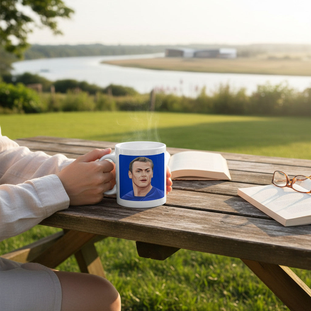 Retrotext Ipswich Town Jim Magilton ceramic mug featuring teletext-style graphic held on a wooden outdoor table.