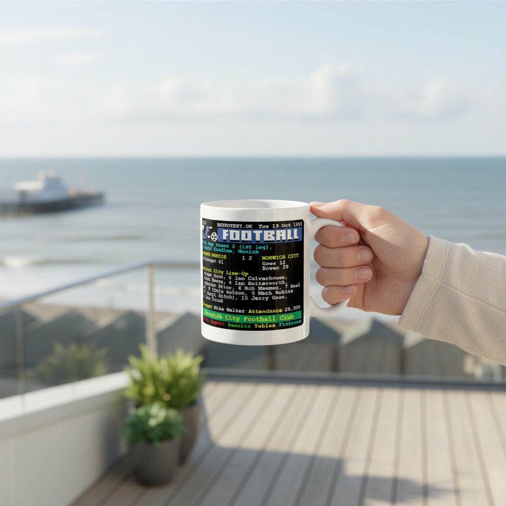 Retrotext white 11oz ceramic mug featuring a 1990s Norwich City football teletext match report held on a balcony.