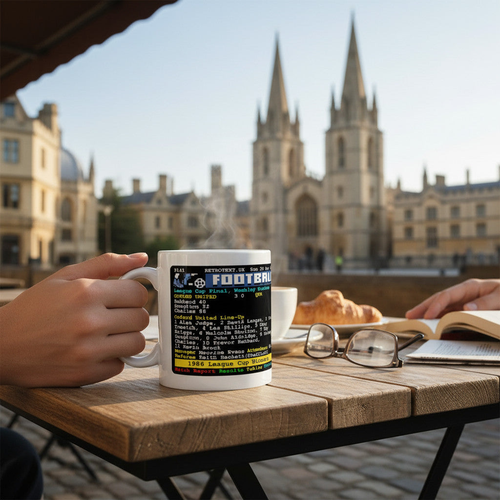 Retrotext white ceramic mug featuring 1986 Oxford United League Cup final teletext score held on an outdoor cafe table