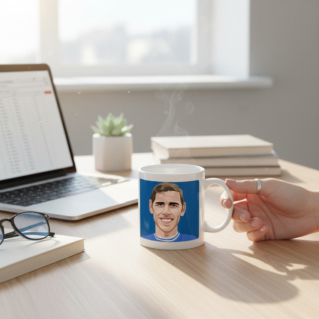 Retrotext ceramic mug featuring a Ray Crawford illustration on a desk with a laptop and books in a bright office